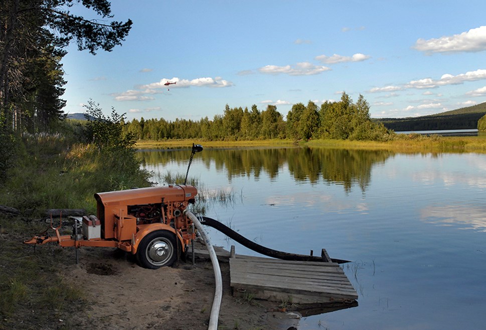 En bensindriven mobil vattenpump pumpar vatten från Luleälven upp till brandområdet och eftersläckningen.