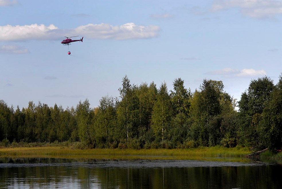 Helikoptrar går i skytteltrafik och hämtar vatten ur Luleälven som sedan bombas över kvarvarande brandhärdar.