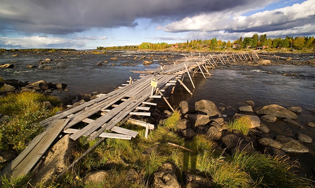Vy över Kukkolaforsen, och en gångbro som går över den.