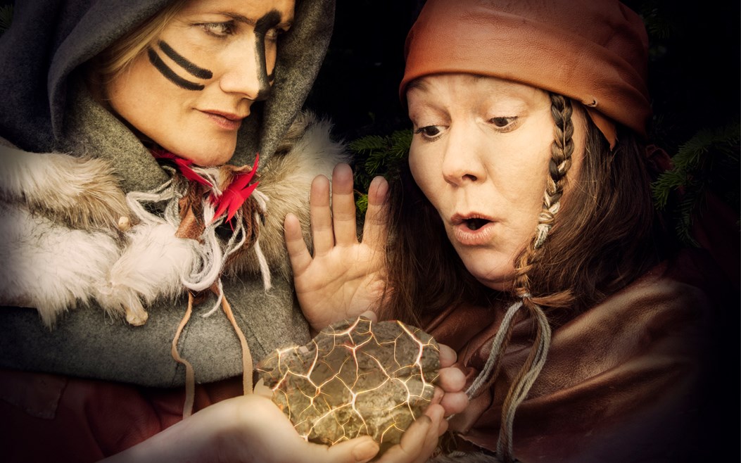 En teaterpjäs där två kvinnor från järnåldern håller i järnklump